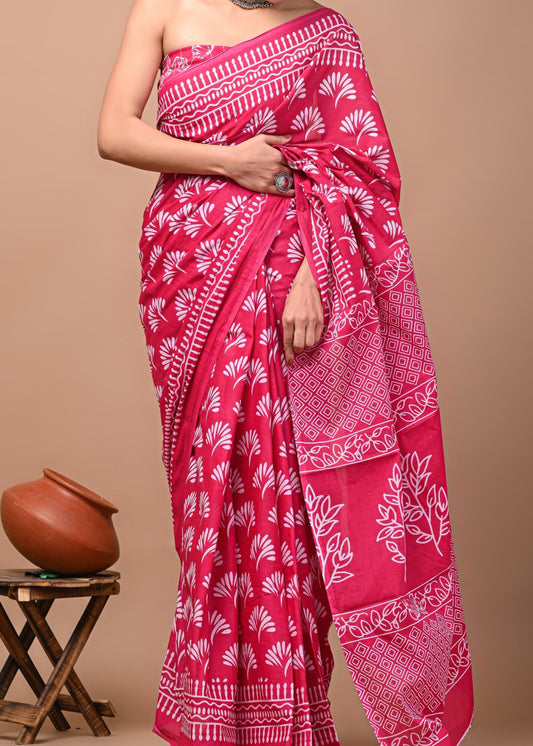 Woman wearing a pink saree with white patterns on a beige background